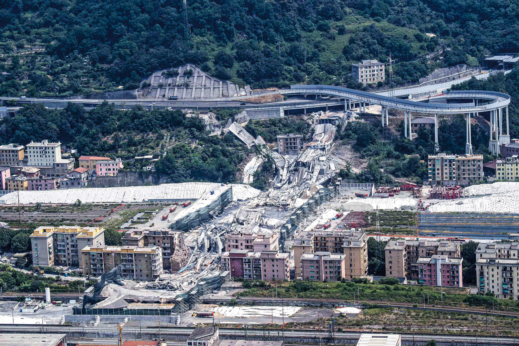 epa07682927 A general view from a Carabinieri helicopter on the rubble following the demolition of the large towers '10' and '11' of the Morandi bridge in Genoa, Italy, 29 June 2019. Thousands of people were evacuated ahead of the demolition works on 28 June 2019. Experts have blown up the remains of the bridge which partially collapsed on 14 August 2018 killing 43 people. A new viaduct replacing the Morandi bridge is expected to be completed by 2020. EPA-EFE/LUCA ZENNARO