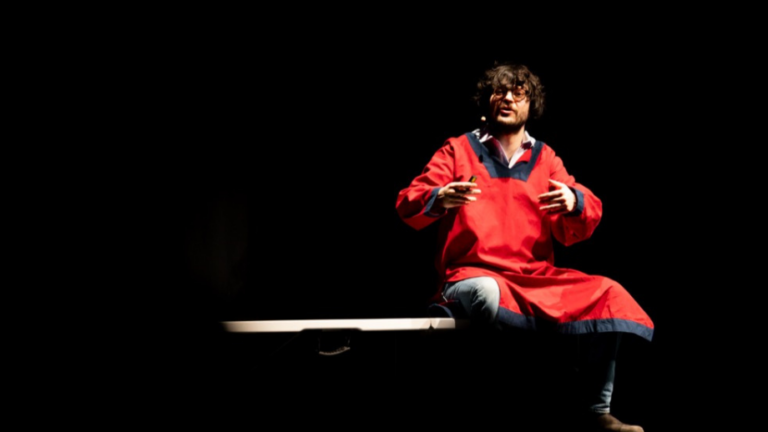 guido damini vestito di rosso su palcoscenico nero